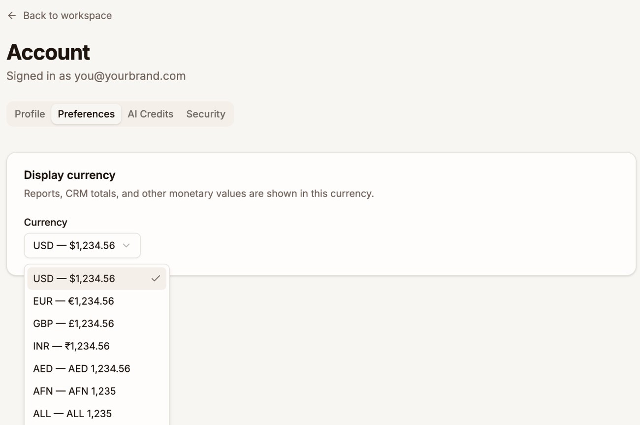 The Preferences tab of the Account page with the Display currency card and its Currency list open, showing currencies such as USD, EUR, and GBP with an example amount in each